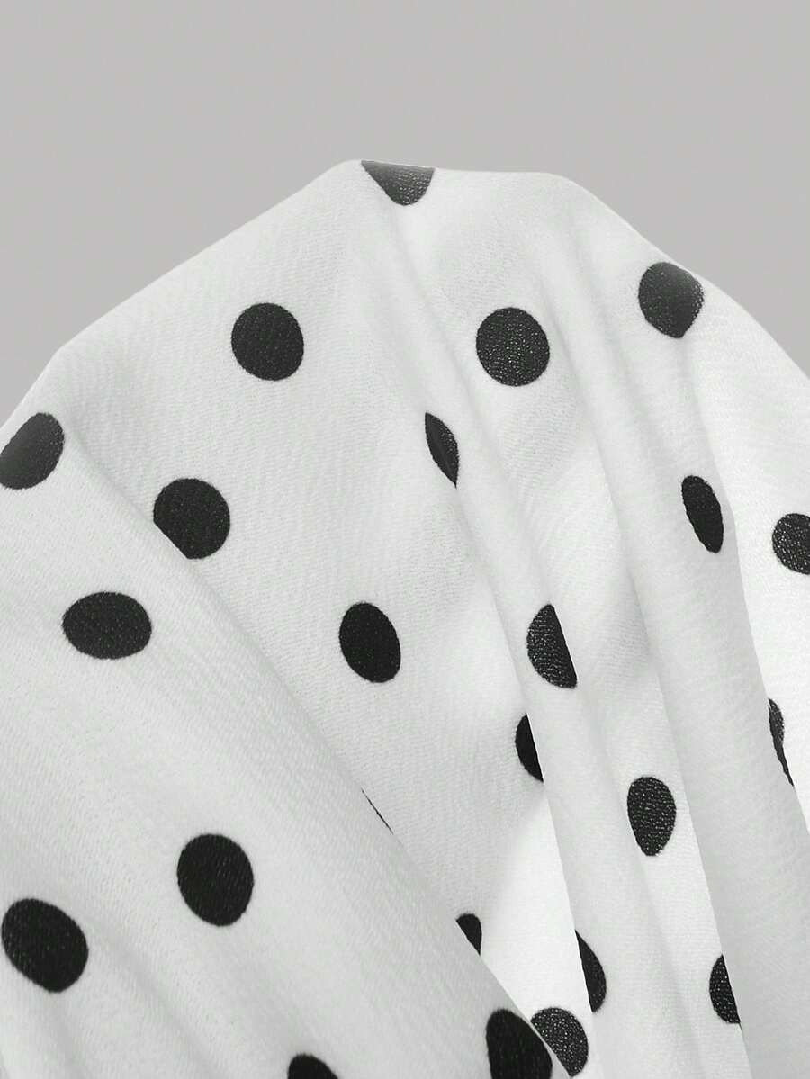 Black and white polka dot cami dress for tween girls featuring a square neckline, high waist, and flared short A-line hem.