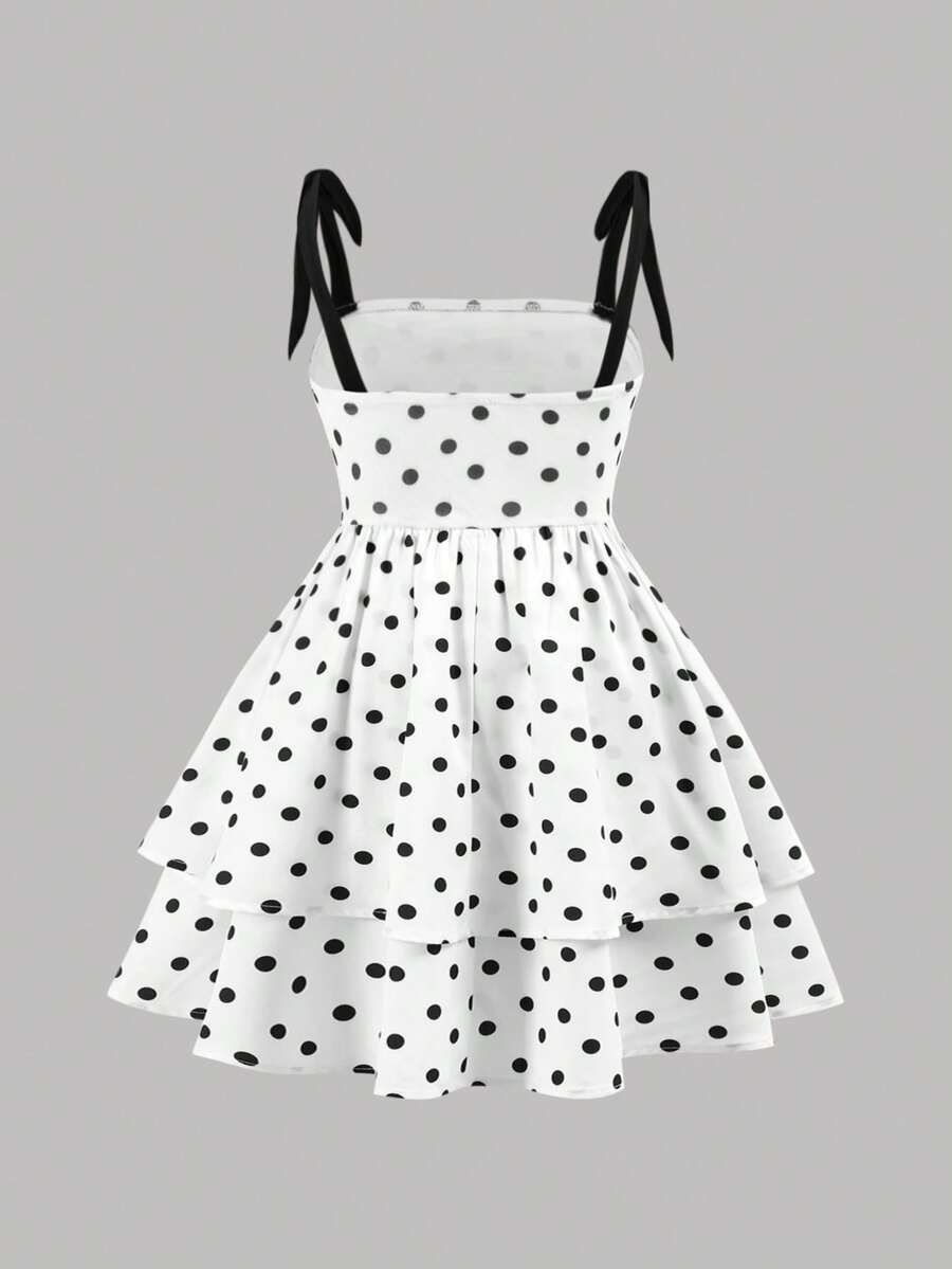 Black and white polka dot cami dress for tween girls featuring sleeveless straps, a shirred high waist, flared hem, and slim fit silhouette.