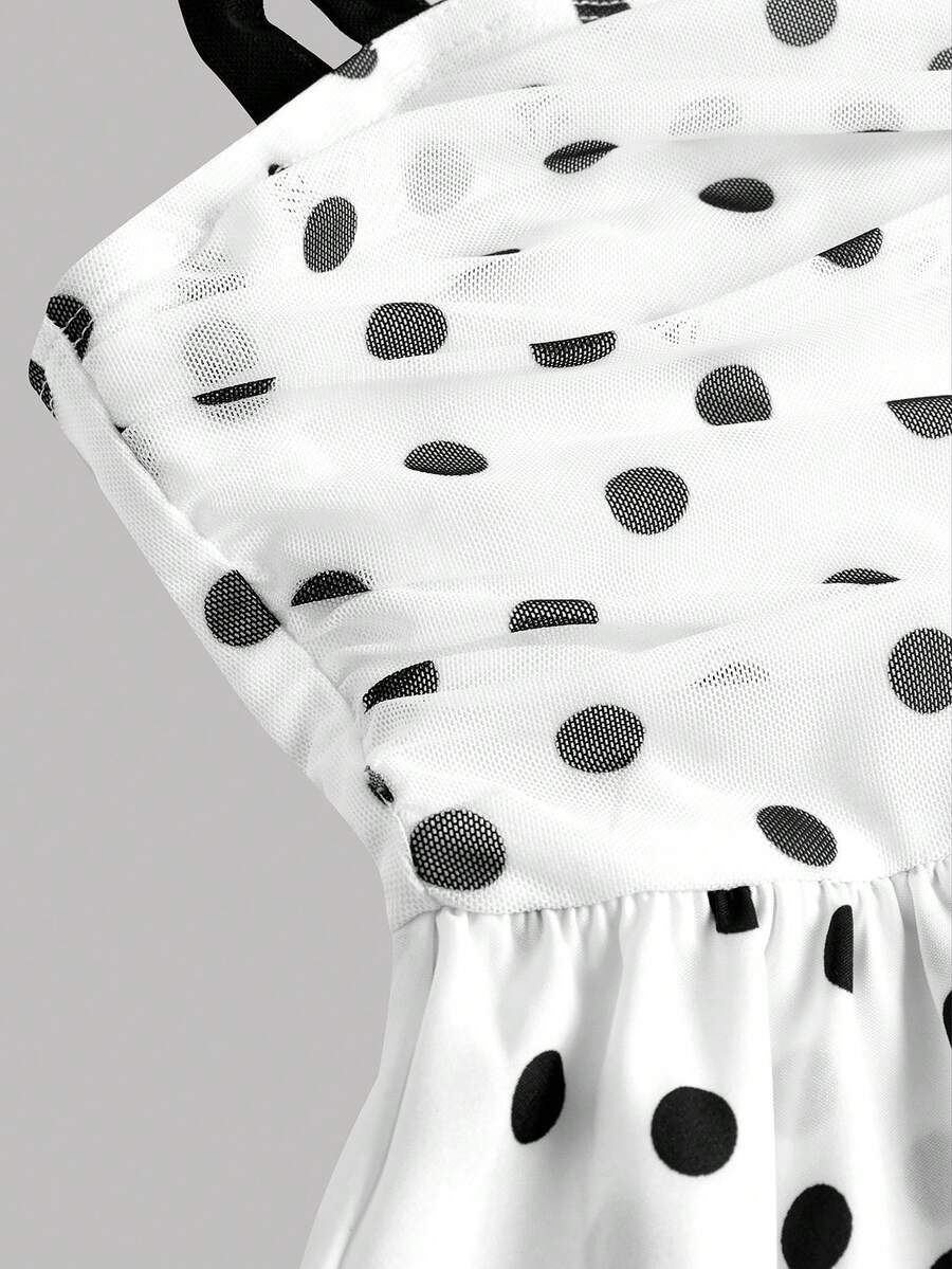 Black and white polka dot cami dress for tween girls featuring sleeveless straps, a shirred high waist, flared hem, and slim fit silhouette.