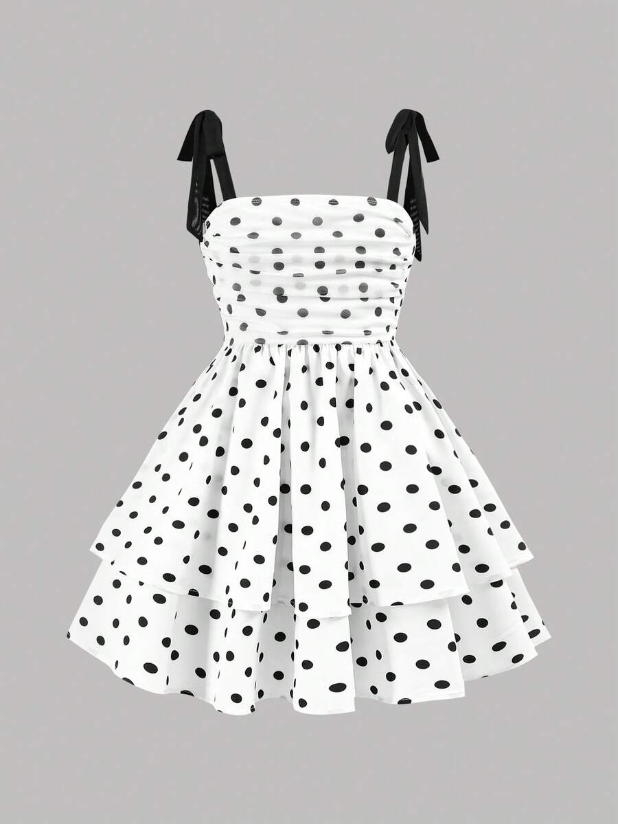 Black and white polka dot cami dress for tween girls featuring sleeveless straps, a shirred high waist, flared hem, and slim fit silhouette.