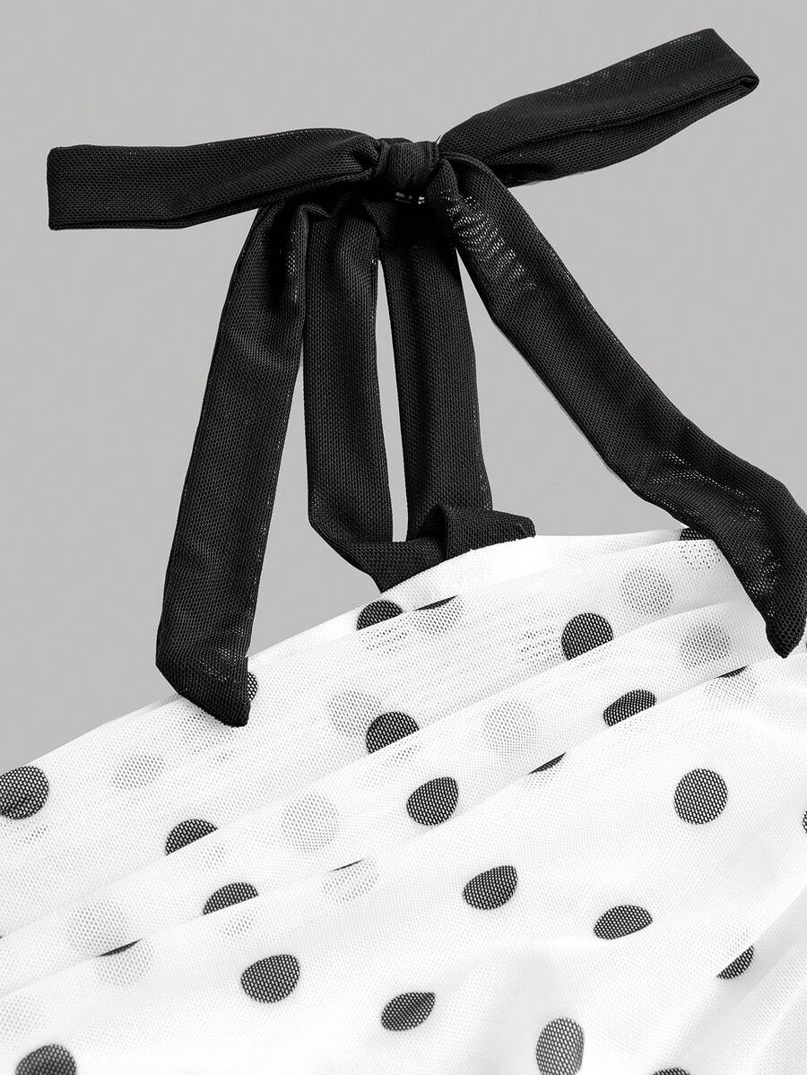 Black and white polka dot cami dress for tween girls featuring sleeveless straps, a shirred high waist, flared hem, and slim fit silhouette.