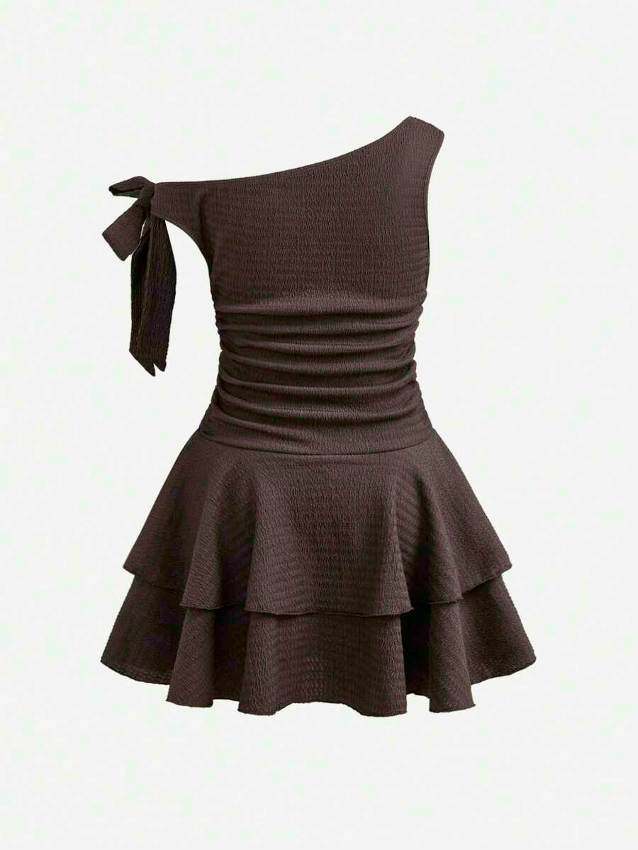 Tween girl wearing an apricot asymmetric skater dress with ruffle and applique details for party and formal occasions.