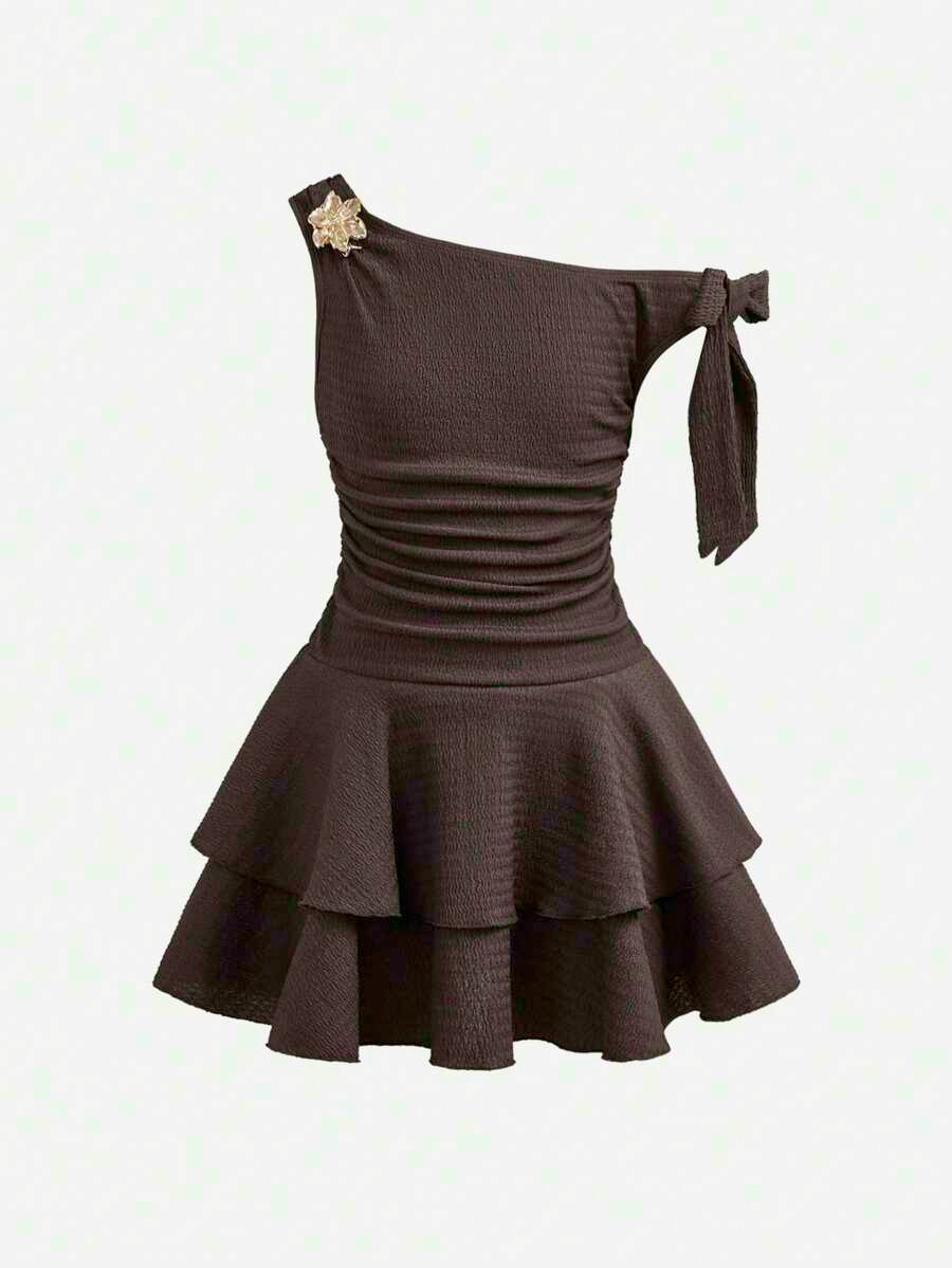 Tween girl wearing an apricot asymmetric skater dress with ruffle and applique details for party and formal occasions.