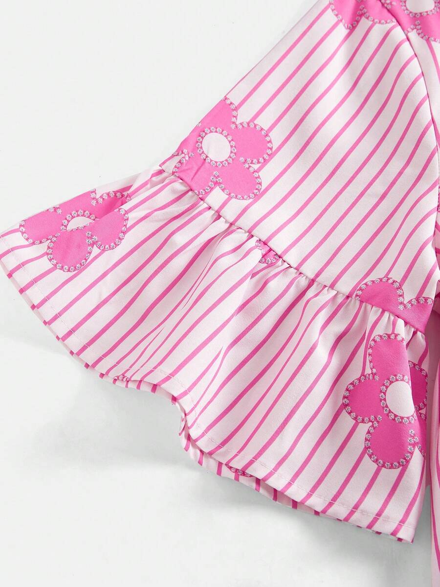 Tween girl wearing a black striped smock shirt dress with flounce half sleeves, a stand collar, and a ruffled hem.