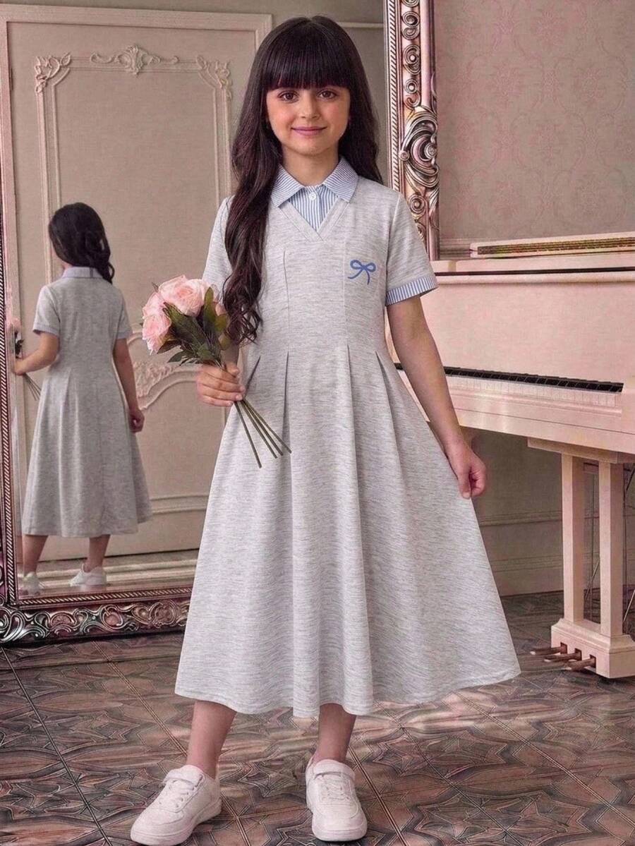Tween girl wearing an apricot short sleeve A-line dress featuring a round neck, high waist with a belt, and flared hem.