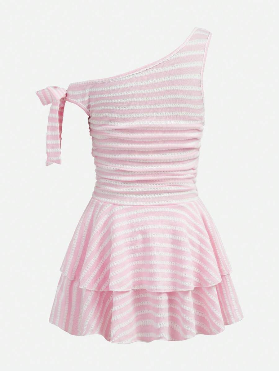 Tween girl wearing an apricot asymmetrical tiered sleeveless party dress with an A-line silhouette.