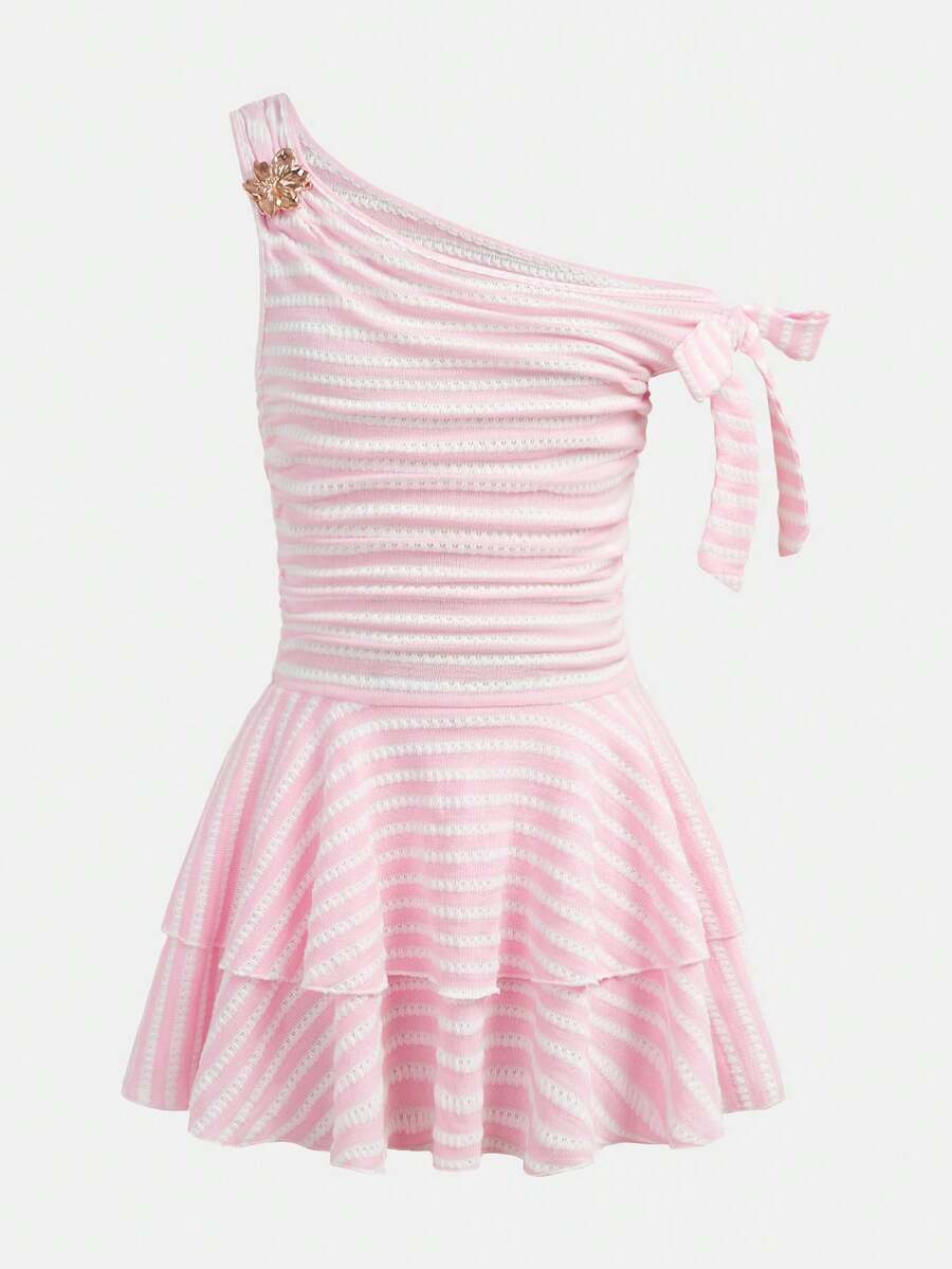 Tween girl wearing an apricot asymmetrical tiered sleeveless party dress with an A-line silhouette.