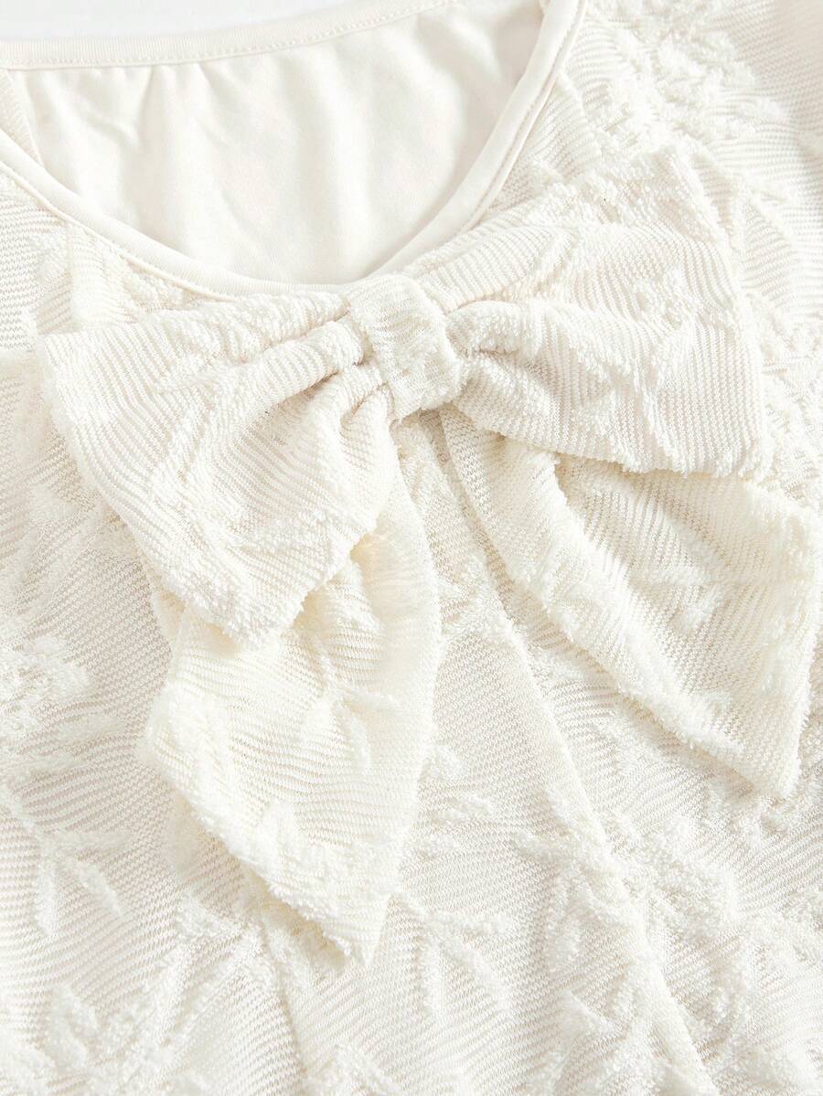 Apricot short-sleeve holiday party dress for tween girls featuring a square neckline, contrast lace details, high waist, flared A-line hem, and bowknot ruffle back detail.
