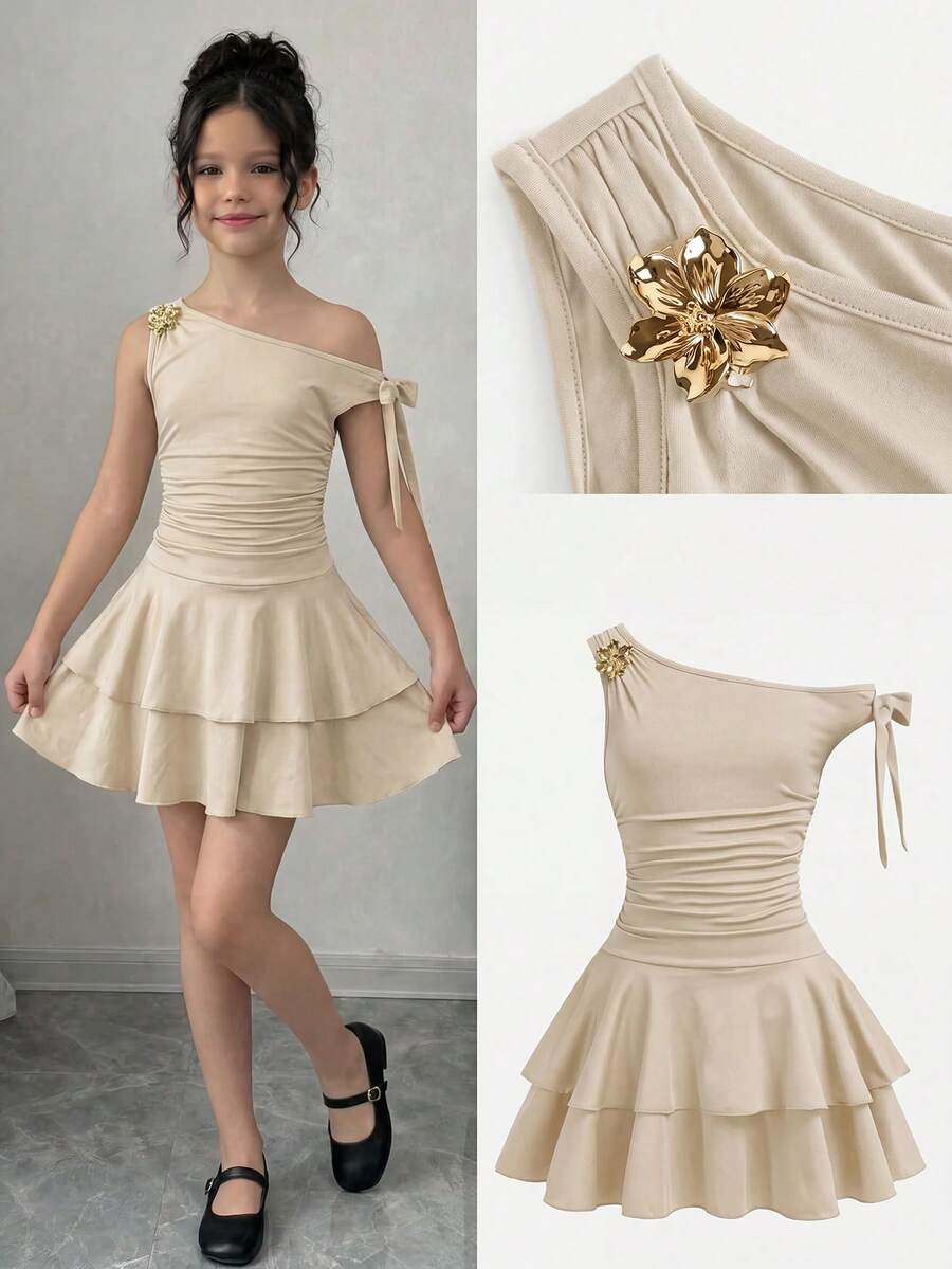 Tween girl wearing an apricot asymmetrical tiered sleeveless party dress with an A-line silhouette.