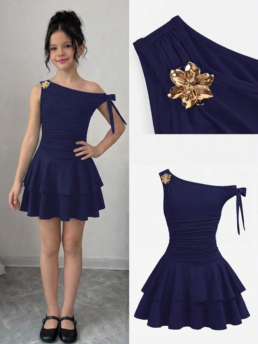 Tween girl wearing an apricot asymmetrical tiered sleeveless party dress with an A-line silhouette.