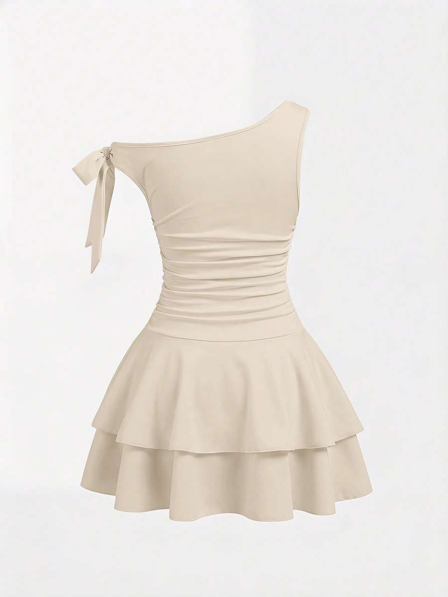 Tween girl wearing an apricot asymmetrical tiered sleeveless party dress with an A-line silhouette.