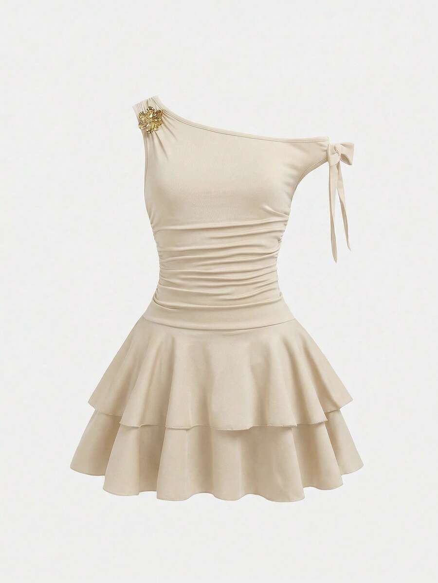 Tween girl wearing an apricot asymmetrical tiered sleeveless party dress with an A-line silhouette.