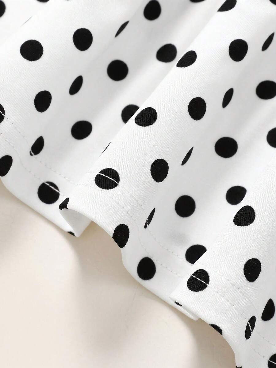 Black sleeveless halter polka dot mini dress for tween girls featuring a high waist and flared hem