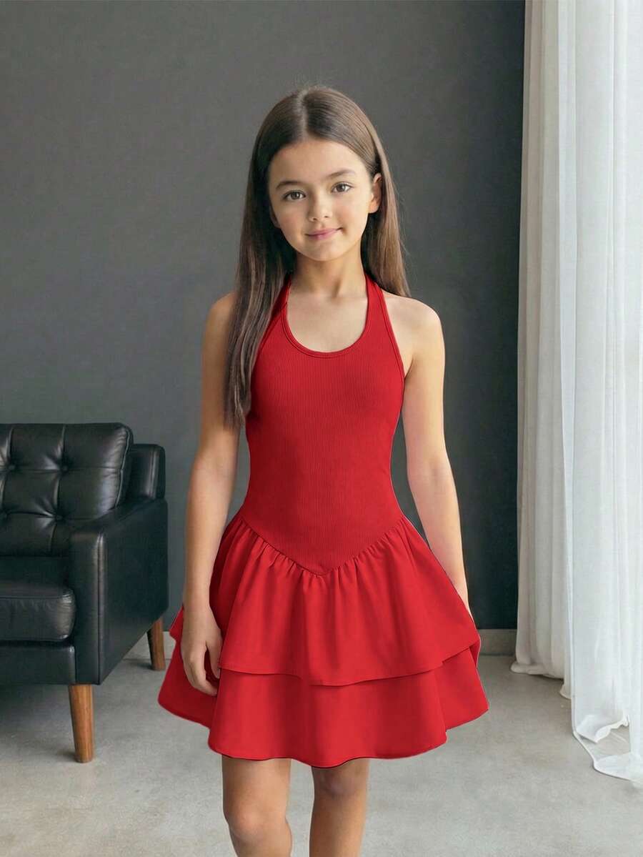 Black sleeveless halter polka dot mini dress for tween girls featuring a high waist and flared hem
