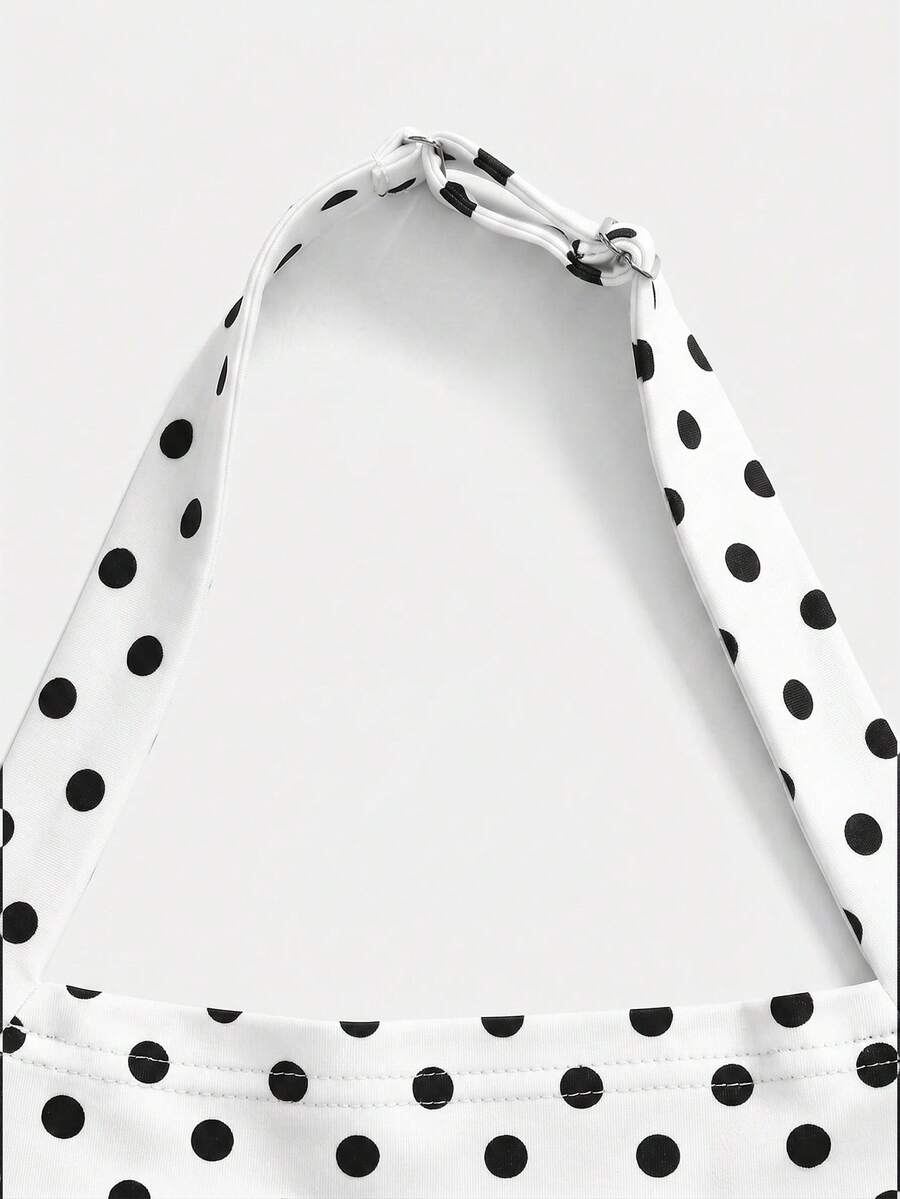 Black sleeveless halter polka dot mini dress for tween girls featuring a high waist and flared hem
