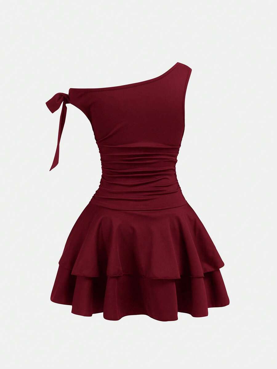 Tween girl wearing an apricot asymmetrical tiered sleeveless party dress with an A-line silhouette.