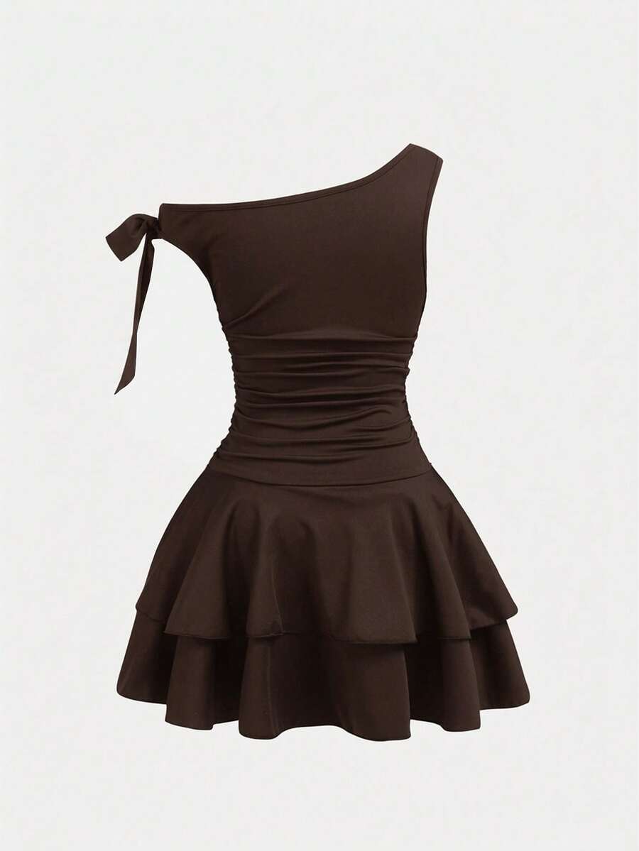 Tween girl wearing an apricot asymmetrical tiered sleeveless party dress with an A-line silhouette.