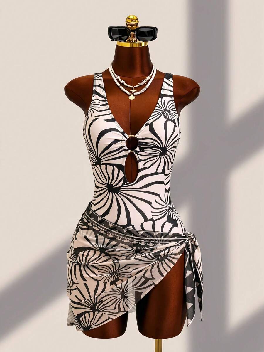 Women's black floral print plunge neck one-piece swimsuit featuring cut-out detail paired with a matching knee-length mesh cover-up skirt