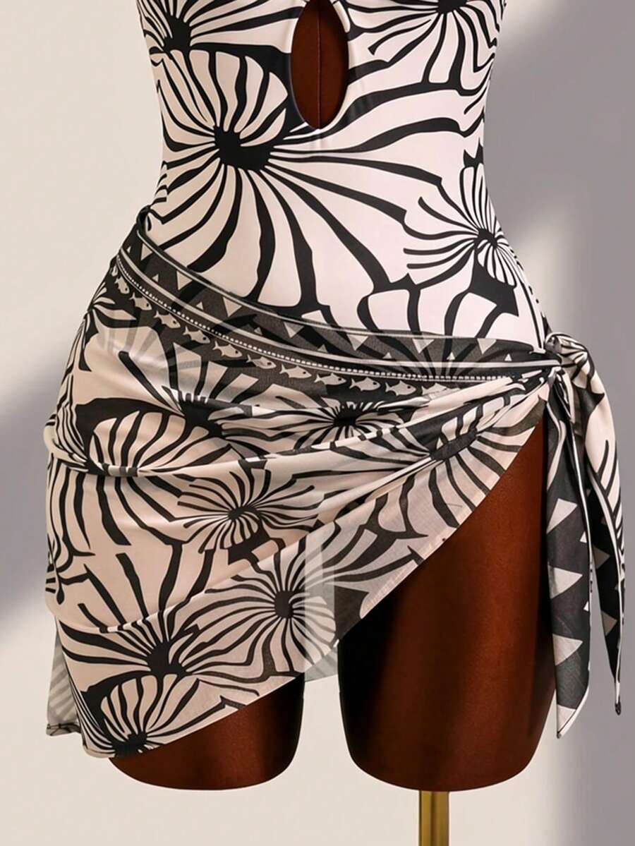 Women's black floral print plunge neck one-piece swimsuit featuring cut-out detail paired with a matching knee-length mesh cover-up skirt