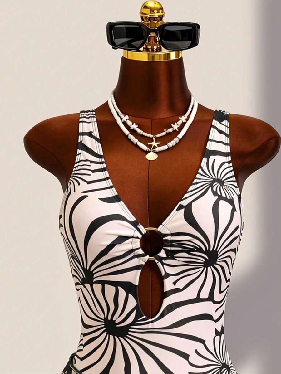Women's black floral print plunge neck one-piece swimsuit featuring cut-out detail paired with a matching knee-length mesh cover-up skirt