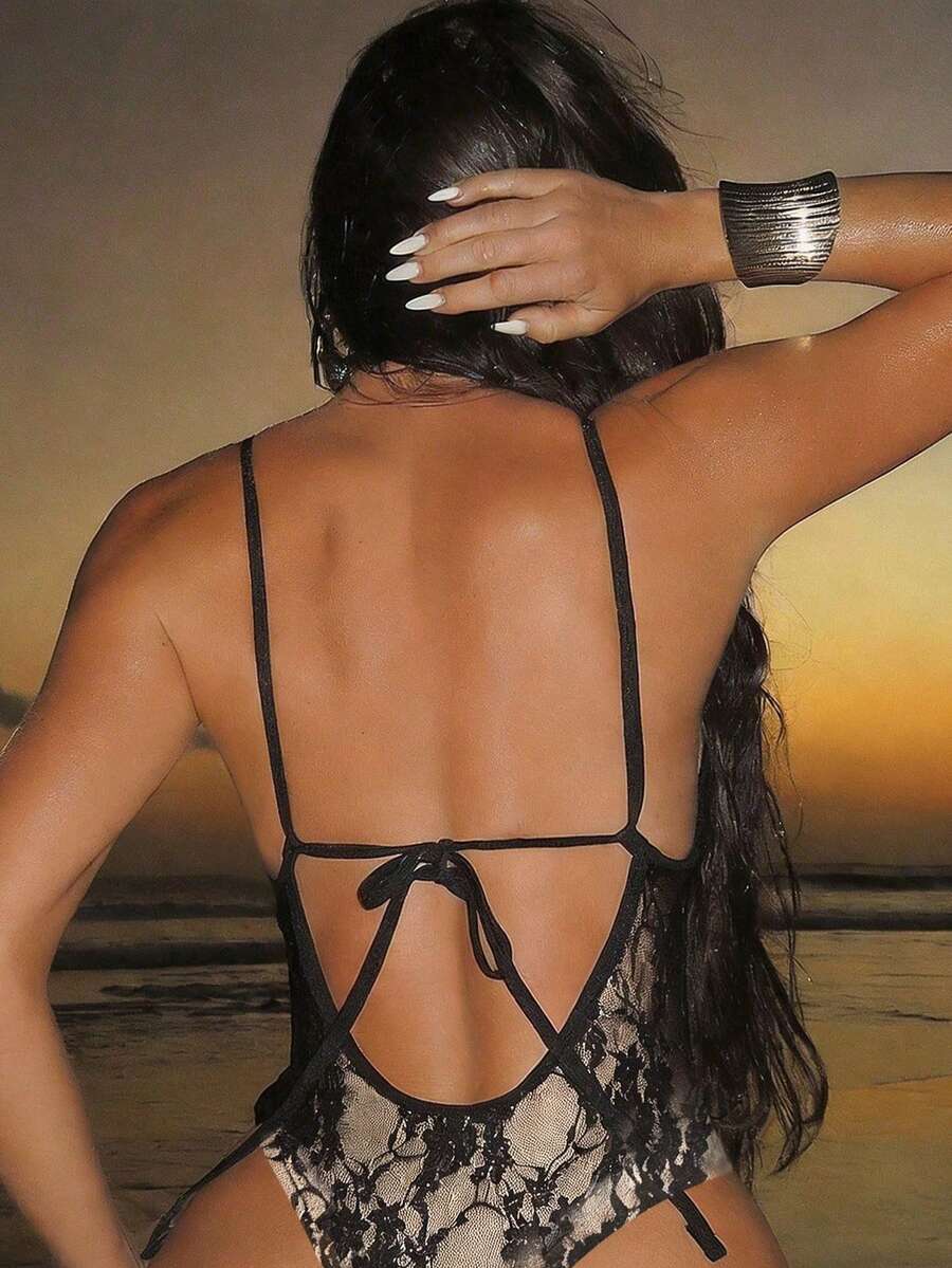 Women's black lace one-piece swimsuit featuring a deep V-neckline, spaghetti straps, backless tie-up detail, and thong bottom.