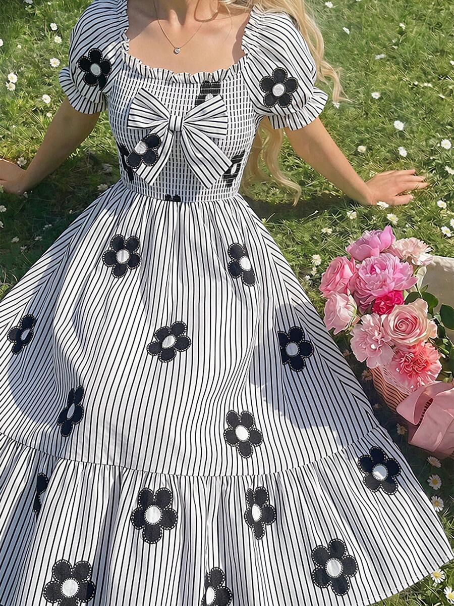 Tween girl wearing a black and white off-the-shoulder floral midi dress featuring short puff sleeves, high waist, and flounce hem.
