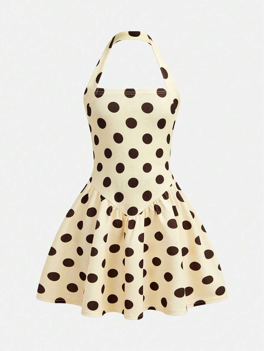 Tween girl wearing a black and white polka dot tiered cami dress with shoulder straps, a high waist, and a ruffle layered hem.