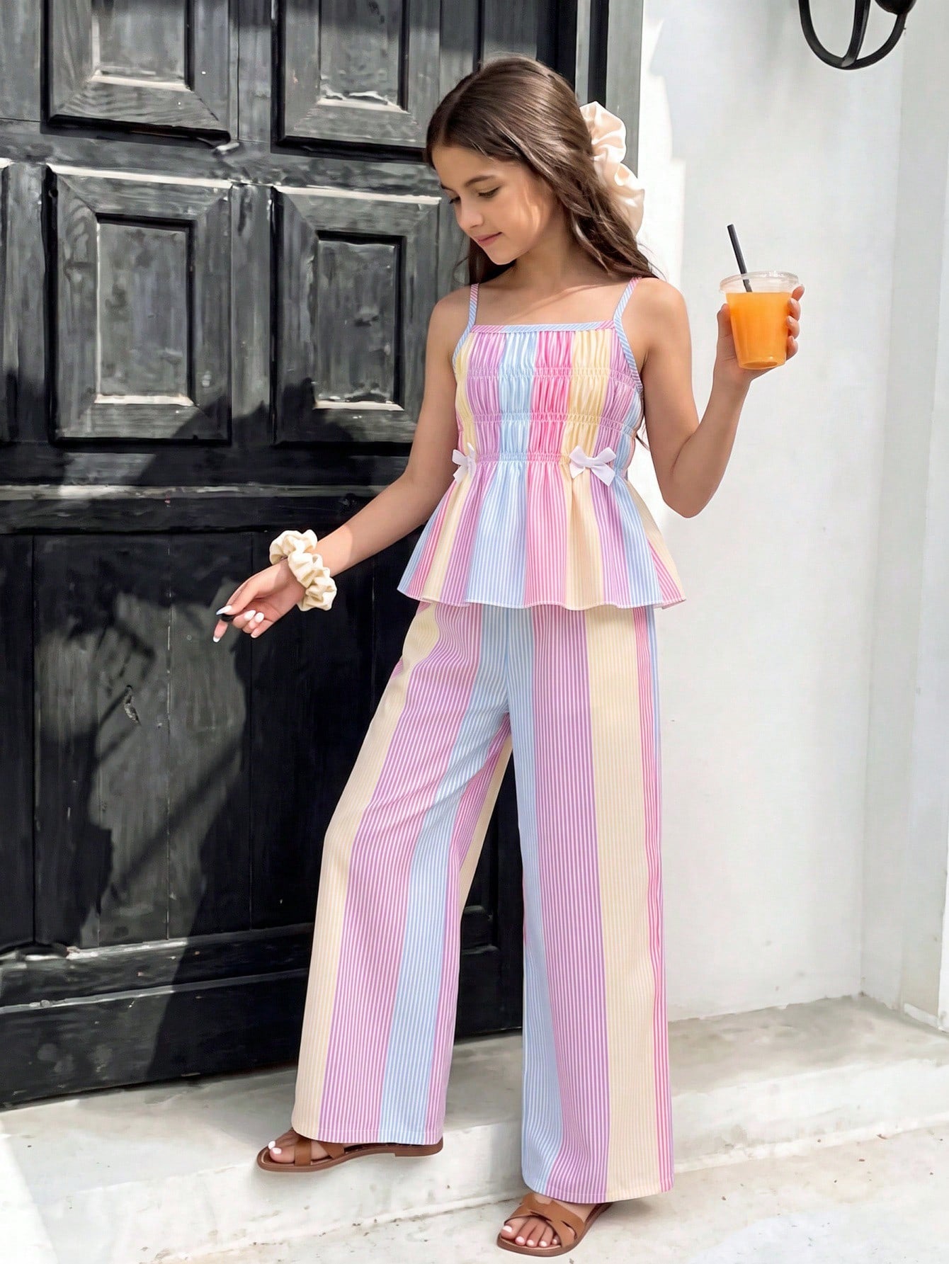 Girls 2-piece summer outfit set featuring a blue bow print camisole top with spaghetti straps and matching high-waisted straight leg pants.
