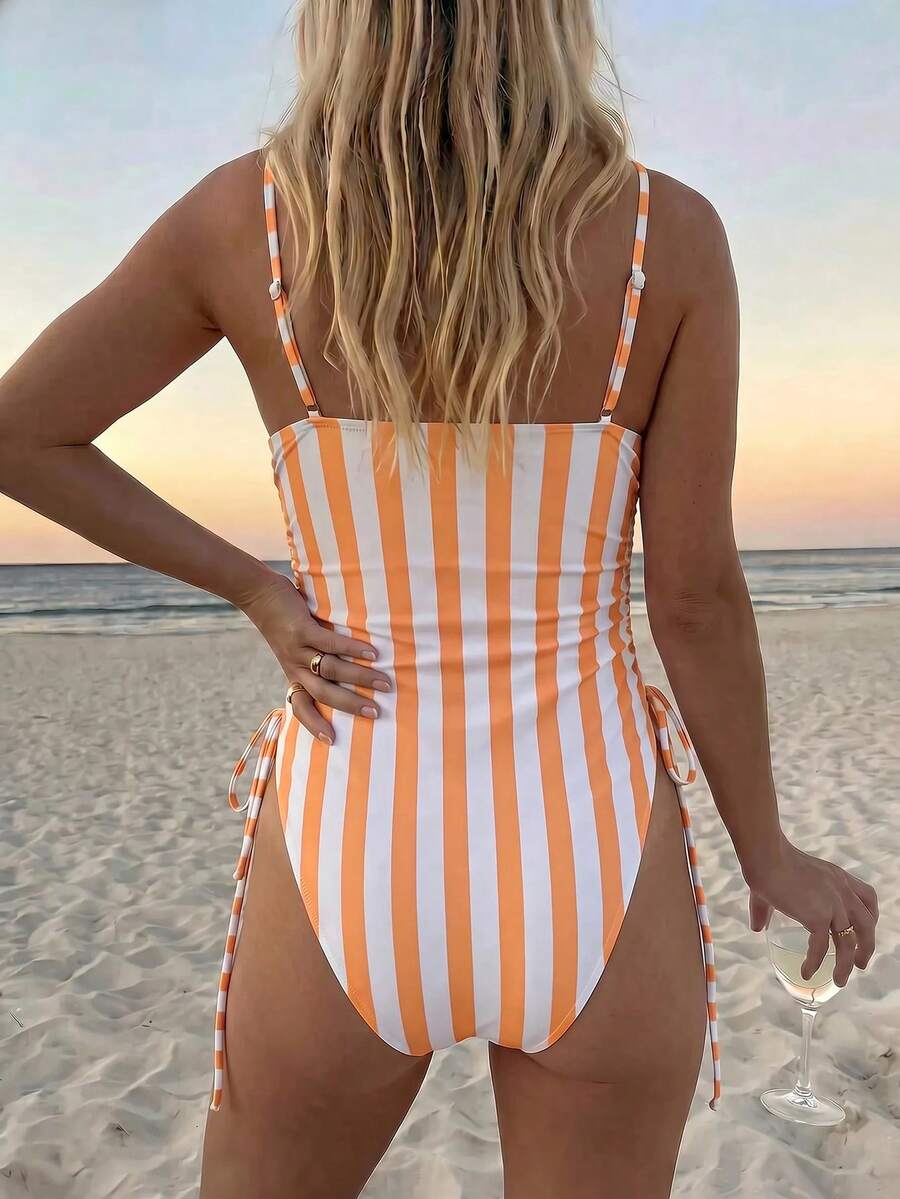 Women's blue backless one-piece swimsuit featuring spaghetti straps, wireless bra with removable padding, and drawstring details.