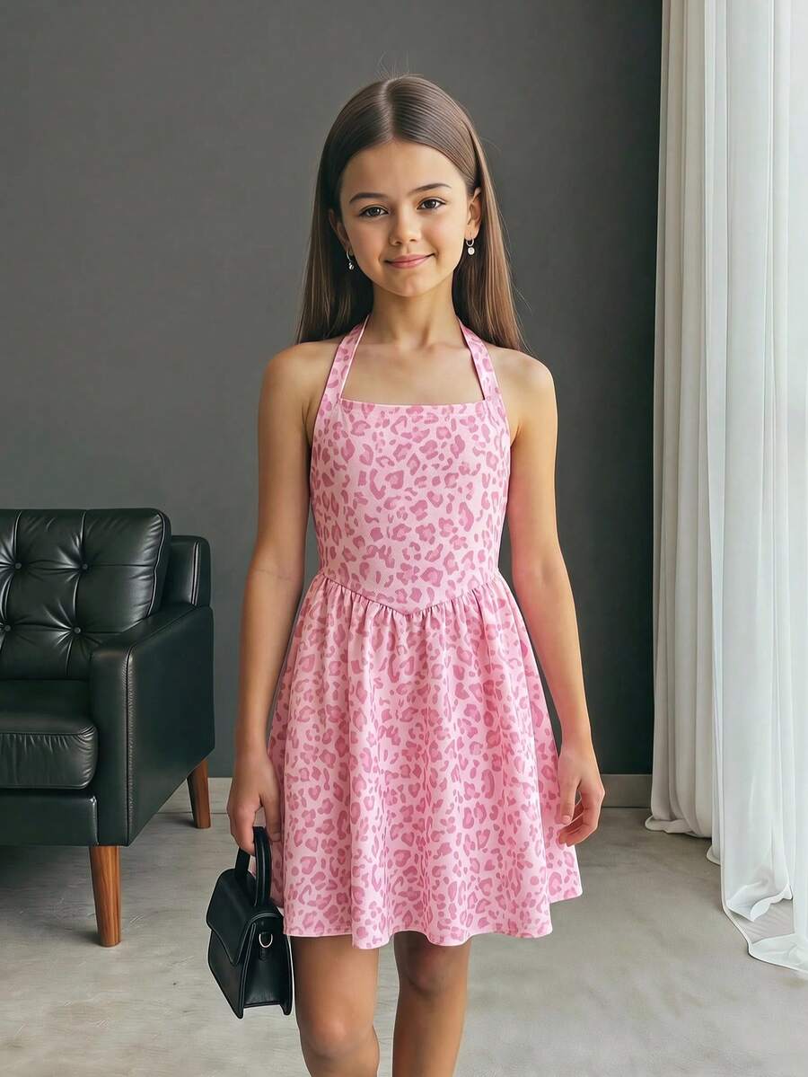 Black sleeveless halter polka dot mini dress for tween girls featuring a high waist and flared hem