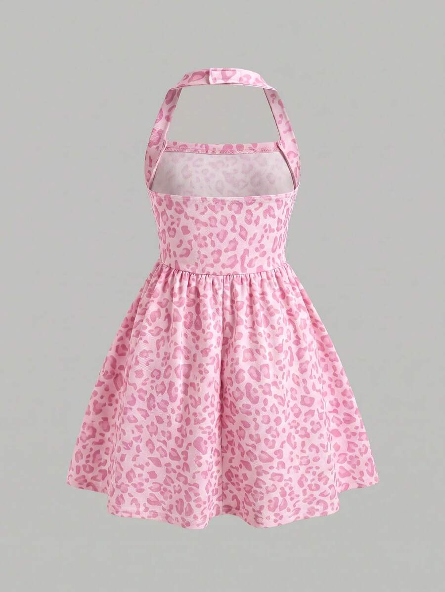 Black sleeveless halter polka dot mini dress for tween girls featuring a high waist and flared hem