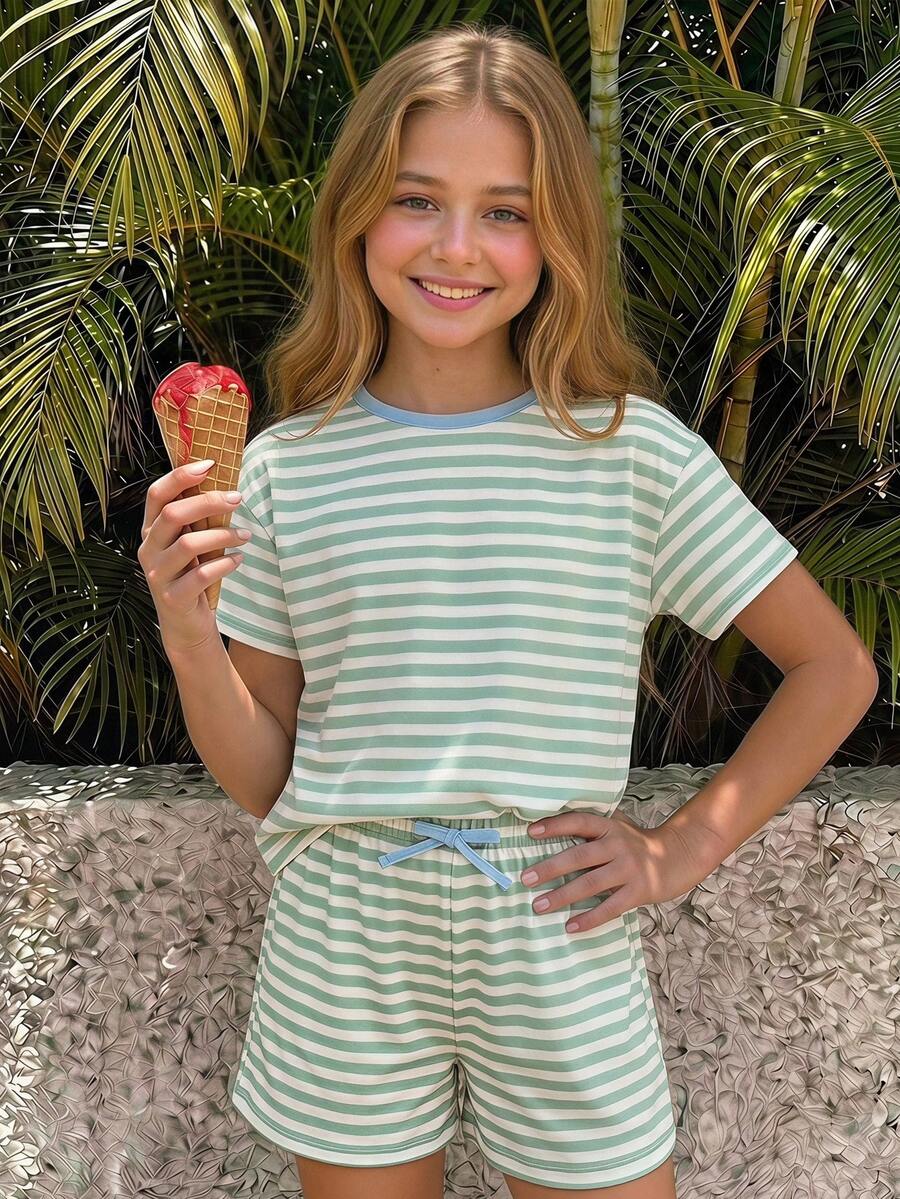 Tween girl wearing a black and white striped drop-shoulder crew neck t-shirt with bow embroidery paired with matching tie-waist shorts.