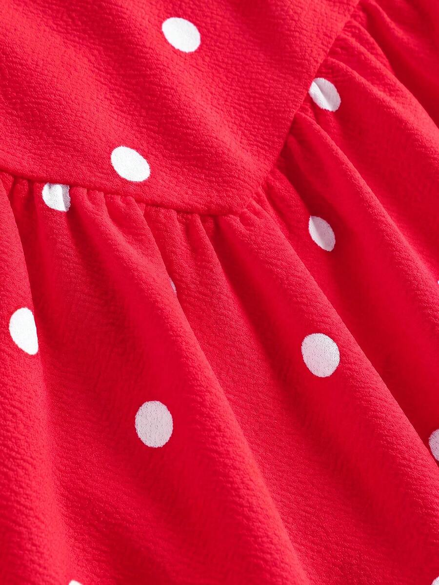 Black sleeveless halter polka dot mini dress for tween girls featuring a high waist and flared hem