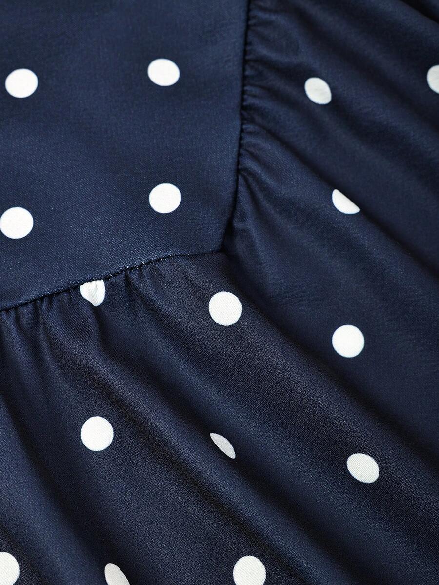 Black sleeveless halter polka dot mini dress for tween girls featuring a high waist and flared hem