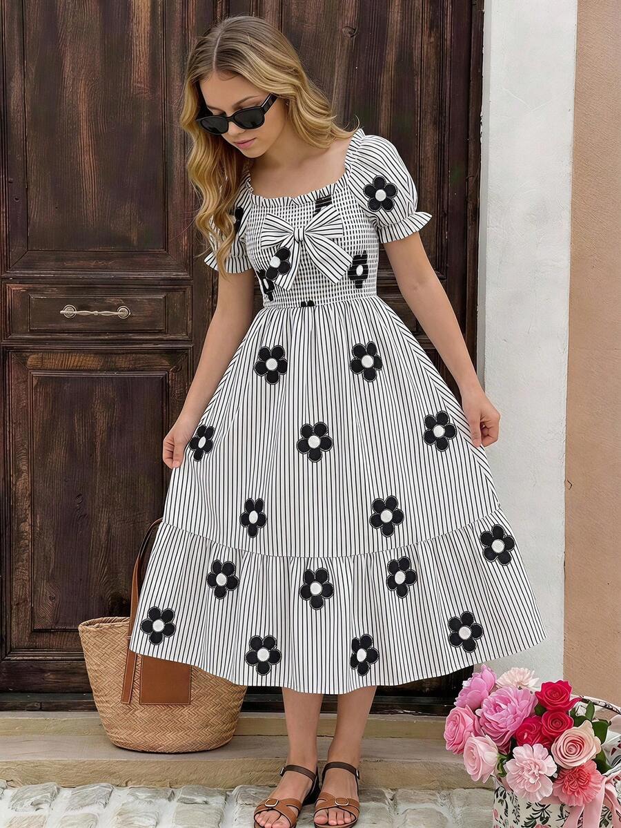 Tween girl wearing a black and white off-the-shoulder floral midi dress featuring short puff sleeves, high waist, and flounce hem.