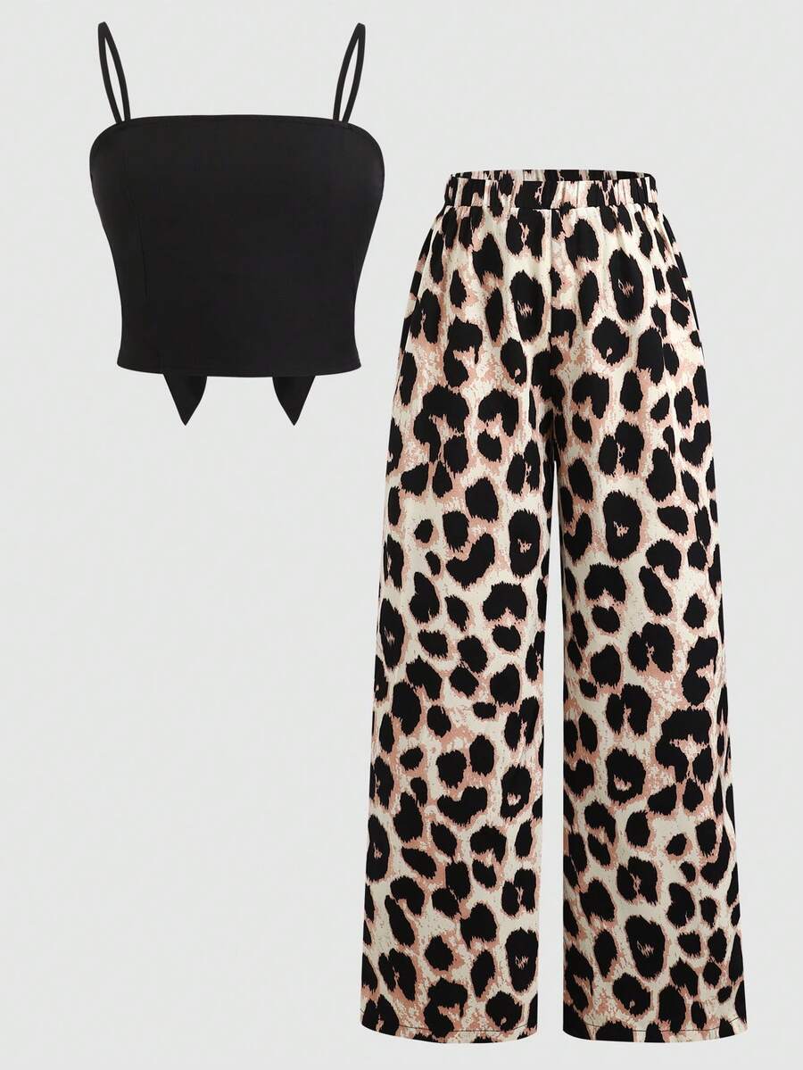Tween girl wearing a black sleeveless spaghetti strap camisole top with 3D bow decor and matching leopard print wide leg long pants.
