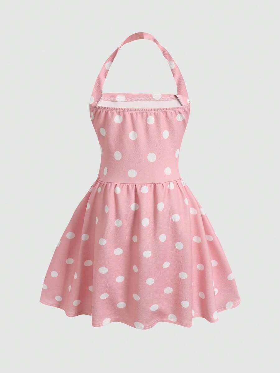 Black sleeveless halter polka dot mini dress for tween girls featuring a high waist and flared hem
