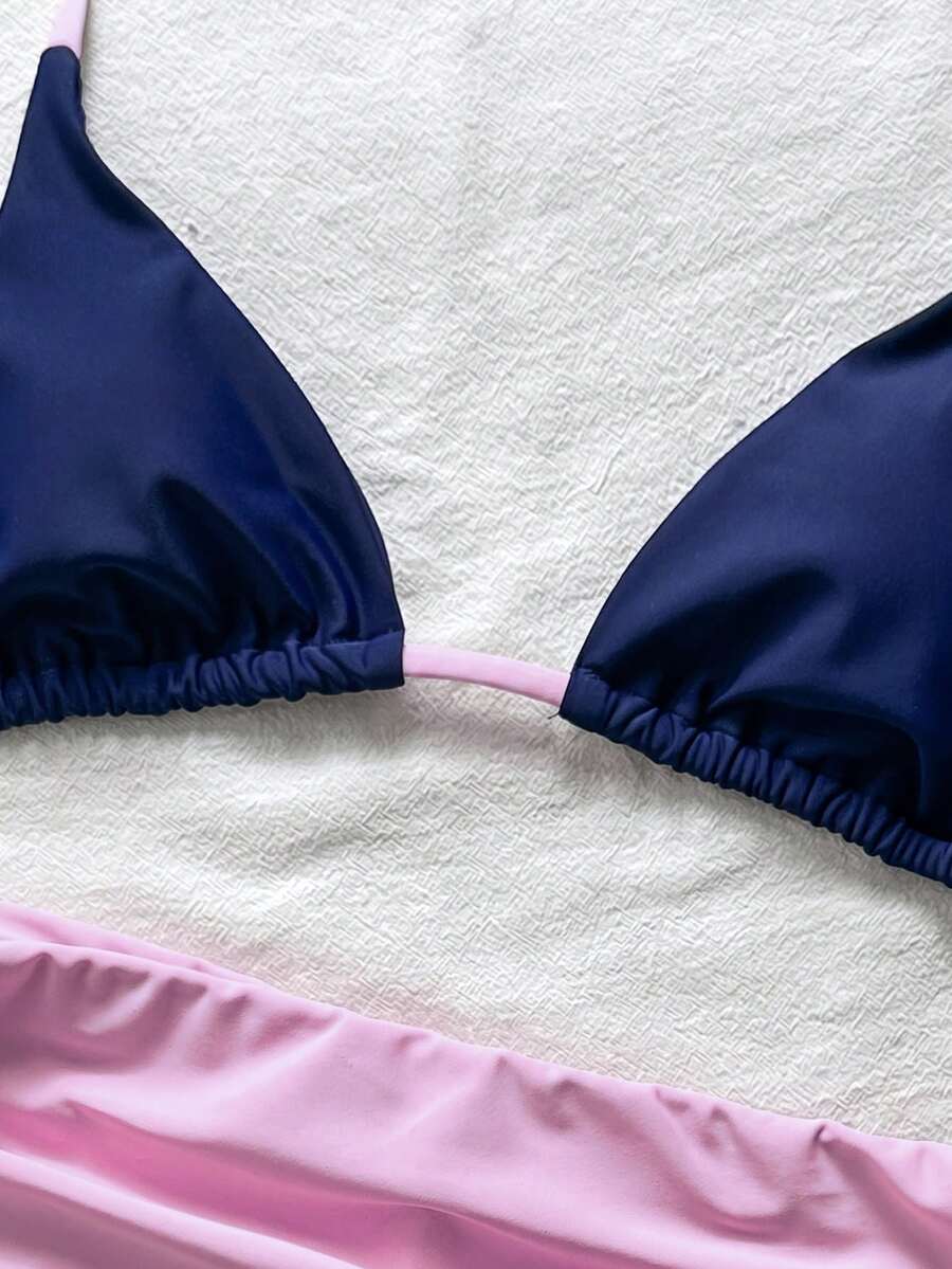 Women's halter triangle bikini top with knot detail paired with mid-waist colorblock swim shorts.