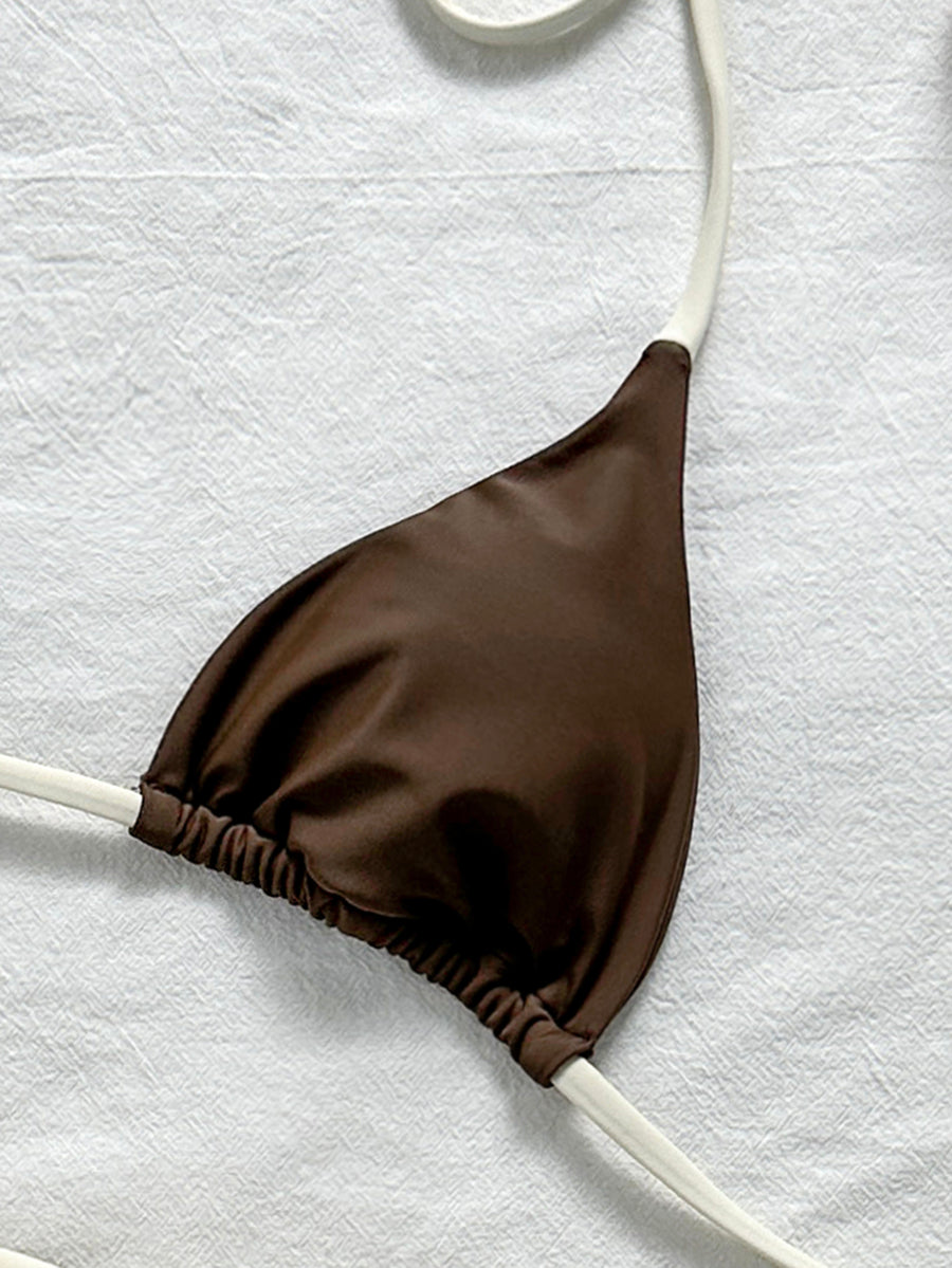 Women's halter triangle bikini top with knot detail paired with mid-waist colorblock swim shorts.