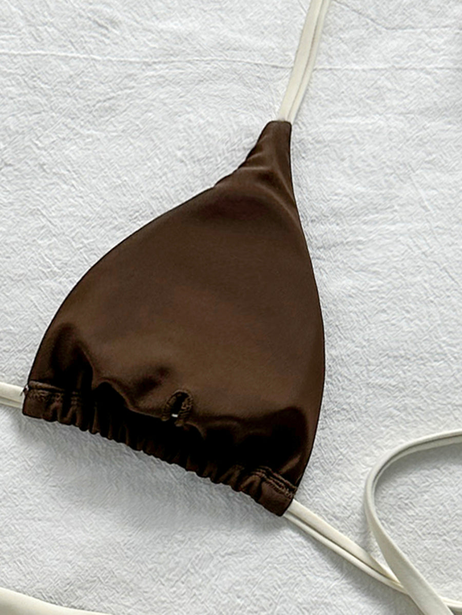 Women's halter triangle bikini top with knot detail paired with mid-waist colorblock swim shorts.