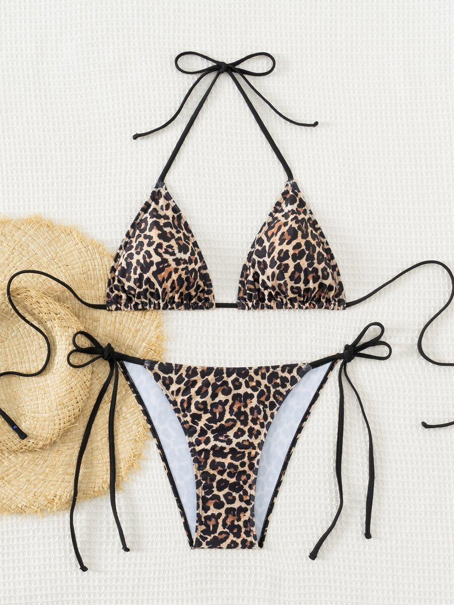 Women's black two-piece bikini set featuring a halter neck with a colorful sun pendant, triangle cups, and high-cut tie-side bottoms.