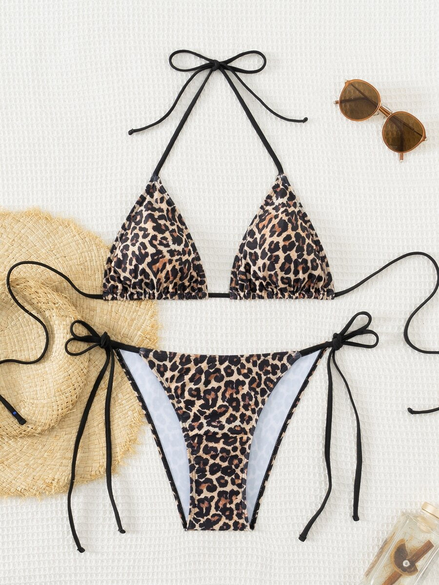 Women's black two-piece bikini set featuring a halter neck with a colorful sun pendant, triangle cups, and high-cut tie-side bottoms.