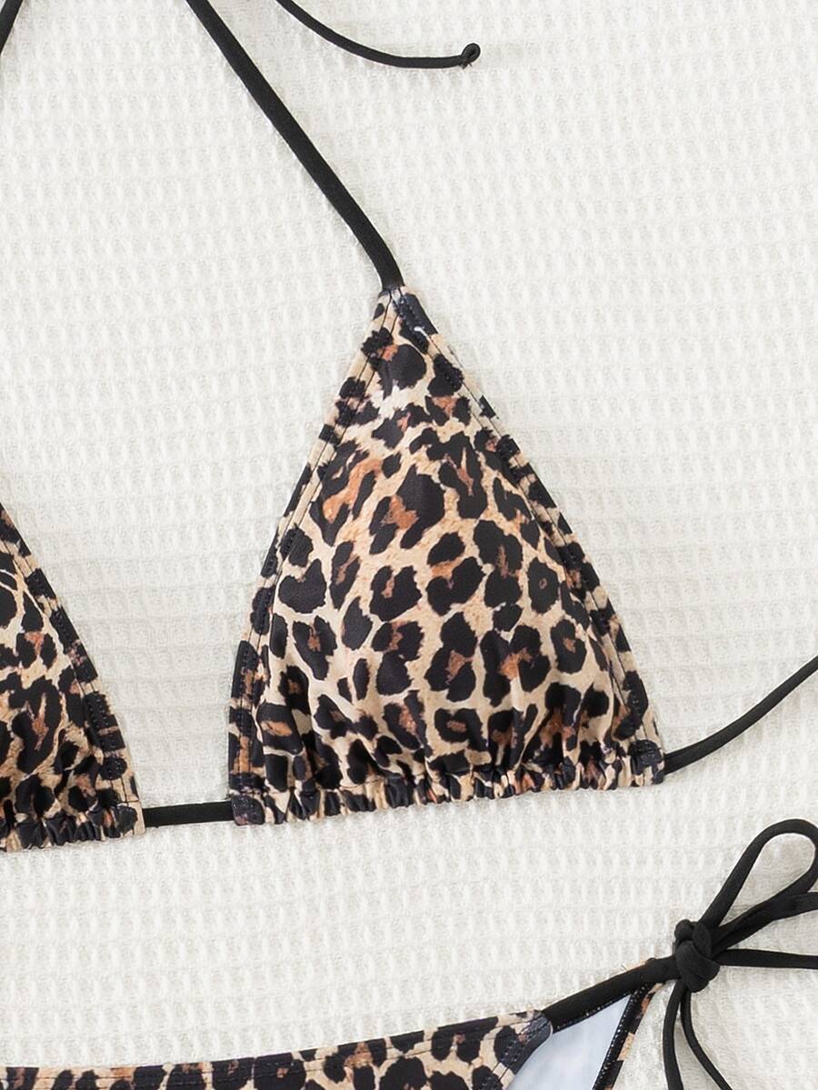 Women's black two-piece bikini set featuring a halter neck with a colorful sun pendant, triangle cups, and high-cut tie-side bottoms.