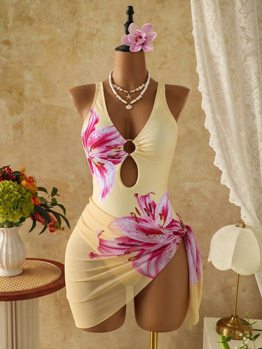 Women's black floral print plunge neck one-piece swimsuit featuring cut-out detail paired with a matching knee-length mesh cover-up skirt